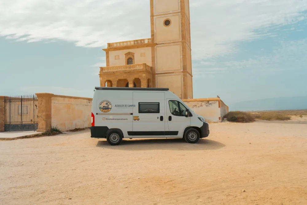 Camper de Nomadcamper junto a un faro de la costa de Almería