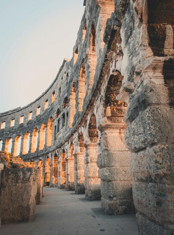Vista de los arcos del anfiteatro de Pula iluminados por la luz del atardecer
